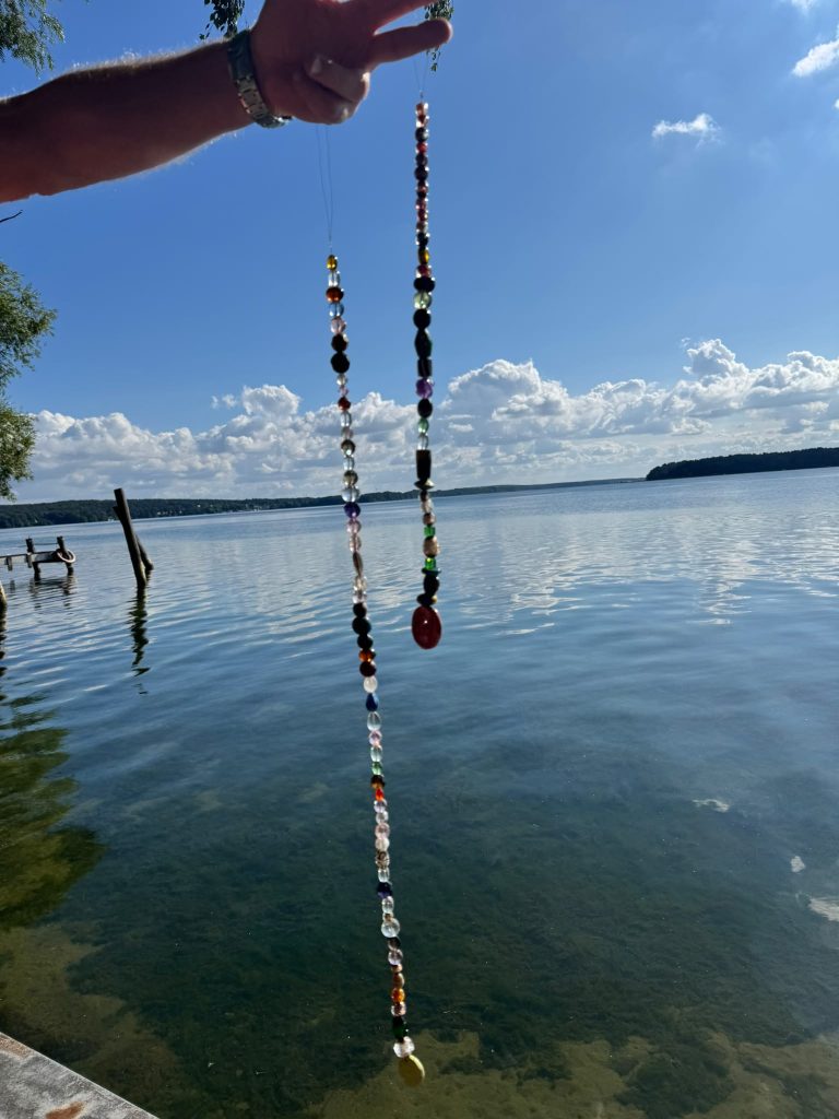 Selbstgemachte Sonnenfänger-Kette aus bunten Glasperlen vor dem Scharmützelsee – Schmuck gestalten im Ferienhof am Trift